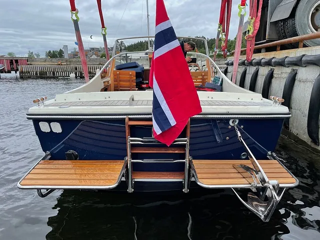 Norges flagg bakpå blå båt
